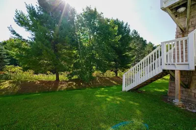 a white staircase on the side of a house at Lower Level LuxSuite - 1min Walk from Heated Pool! in Shanty Bay