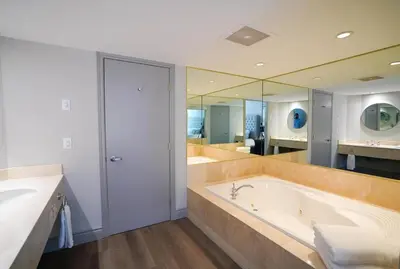 a large bathroom with a tub and a large mirror at Lower Level LuxSuite - 1min Walk from Heated Pool! in Shanty Bay