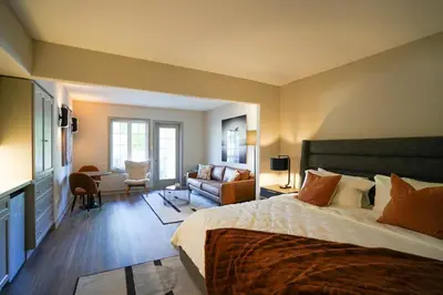 a bedroom with a large bed and a living room at Modern, fully renovated Studio! in Shanty Bay