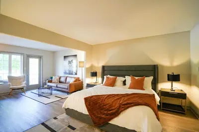 a bedroom with a large bed and a couch at Modern, fully renovated Studio! in Shanty Bay