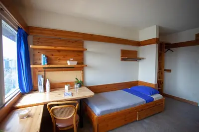 a bedroom with a bed and a desk and a table at Tartu College Student Residence in Toronto