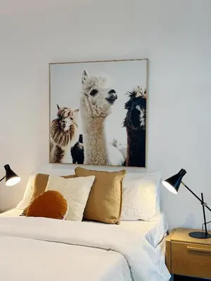 a picture of llamas on the wall above a bed at INFIVILLA King Suites & Towers Soho Toronto in Toronto