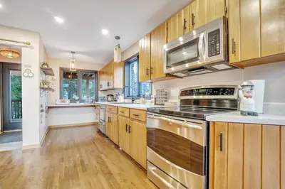 a kitchen with wooden cabinets and stainless steel appliances at Luxurious waterfront cottage in Bowmanville