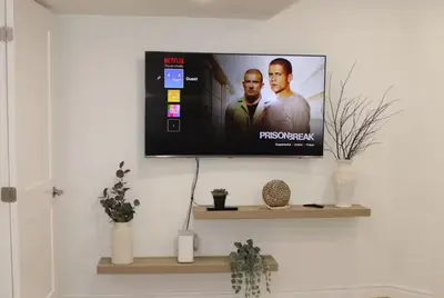a flat screen tv on a wall in a living room at Queen Bed Suite-Private Entrance in Barrie