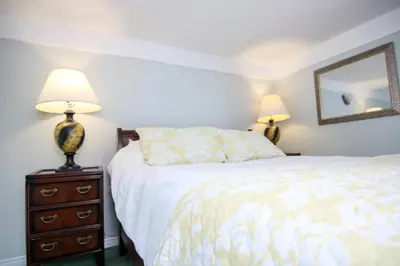 a bedroom with a bed and two lamps on a dresser at The Jypsy Inn - The Royal Suite Bracebridge in Bracebridge