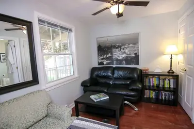 a living room with a leather couch and a table at The Jypsy Inn - Tuxedo Room Muskoka in Bracebridge