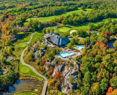 an aerial view of a golf course with trees and water at Luxury Muskoka Retreat in Gravenhurst
