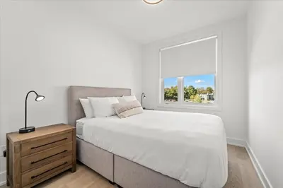 a white bedroom with a bed and a window at Luxury Muskoka Retreat in Gravenhurst