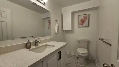 a white bathroom with a sink and a toilet at Cozy 1BR Garden Suite Innisfil Beach Park in Innisfil