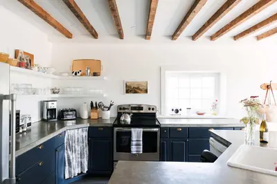 a kitchen with blue cabinets and a black stove at Babcock-Hubbs House in Carrying Place