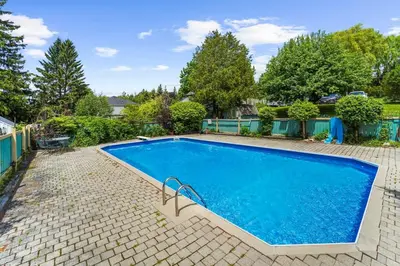 a swimming pool with blue water in a yard at The Wynford Elora The Monroe Suite in Elora
