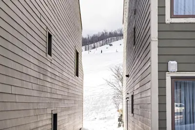 a side view of a building with a snow covered slope at Blue Mountain Haus - Private Patio - Walk to Blue in Blue Mountains