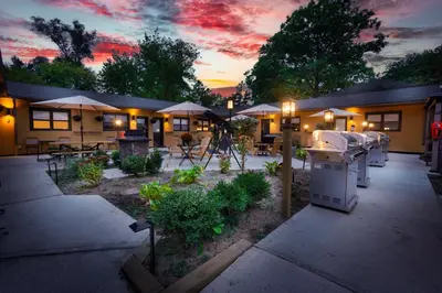 a resort building with a grill and tables and umbrellas at Adrian's Suites 1 Bedroom Junior Suite in Wasaga Beach