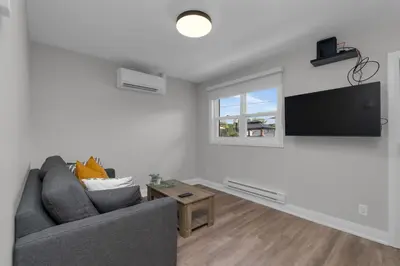 a living room with a couch and a flat screen tv at Adrian's Suites 1 Bedroom Junior Suite in Wasaga Beach