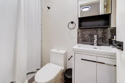 a white bathroom with a toilet and a sink at Adrian's Suites 1 Bedroom Junior Suite in Wasaga Beach