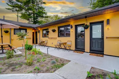 a yellow house with a table and chairs at Adrian's Suites 2Bedroom Family Suite in Wasaga Beach