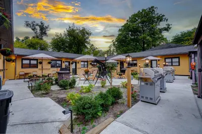 a building with a patio with tables and umbrellas at Adrian's Suites 1Bedroom Junior Suite in Wasaga Beach