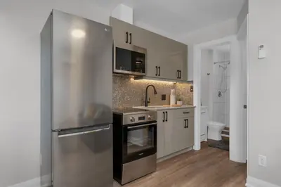 a kitchen with a stainless steel refrigerator and a sink at Adrian's Suites 1Bedroom Junior Suite in Wasaga Beach