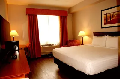 a hotel room with a bed and a window at Staywell Inn & Suites in London