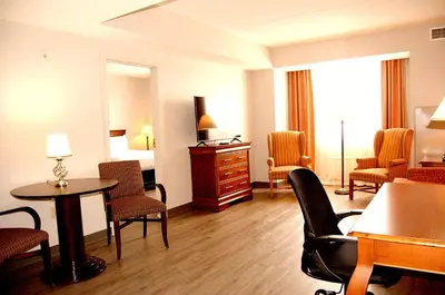 a room with chairs and a table in a hotel room at Staywell Inn & Suites in London