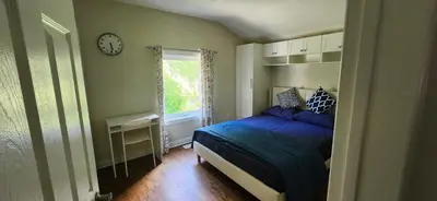 a bedroom with a bed and a clock on the wall at Sunny Corner Room with View in Toronto