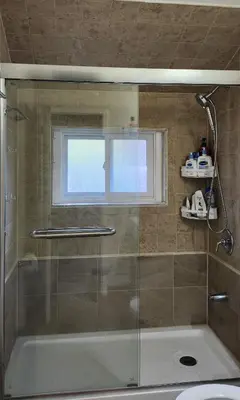 a bathroom with a shower and a tub and a window at Sunny Corner Room with View in Toronto