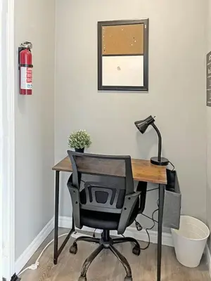 a desk with a computer chair and a lamp at Cozy Retreat with Netflix and Work Desk in Fort Erie