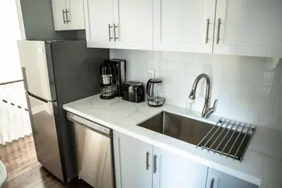 a kitchen with a sink and a refrigerator at Inviting 2BR Townhouse with 2 WFH Setups and WiFi in Toronto