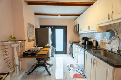 a kitchen with a sink and a table in it at Stylish 2BR Home with Front Yard and Free Parking in Toronto