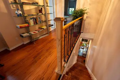 a hallway with a staircase with a book shelf at Stylish 2BR Home with Front Yard and Free Parking in Toronto