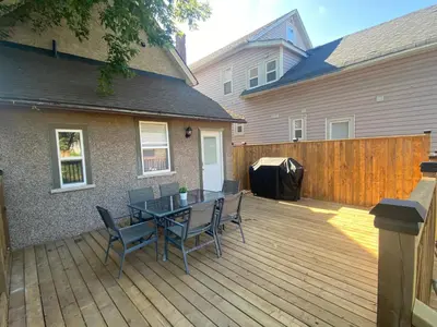 a patio with a table and chairs on a wooden deck at Rock place in Niagara Falls