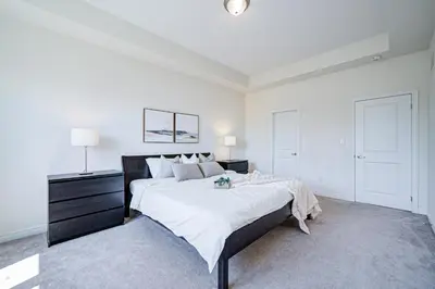 a white bedroom with a large bed and a dresser at Richland Modern Luxury house in Richmond Hill