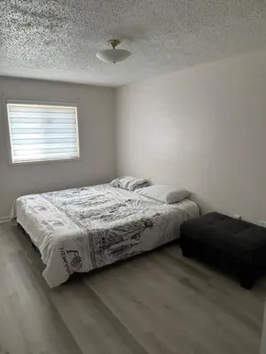 a white bedroom with a bed and a window at Cozy Ajax Stay for Families in Ajax