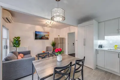 a kitchen and living room with a table and a couch at The Bloor Spadina Getaway With 3-Bedroom and Private Patio in Toronto