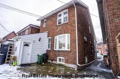 a brick house with a white garage in front of it at 132 Chatham ave in Toronto