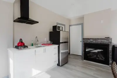 a kitchen with a refrigerator and a fire place at 3-Bedroom Cottage #7 - Austrian Pine in Gravenhurst