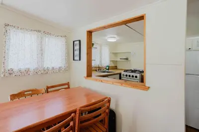 a kitchen with a wooden table and a mirror at 2-Bedroom Cottage #5 - Lodgepole Pine in Gravenhurst
