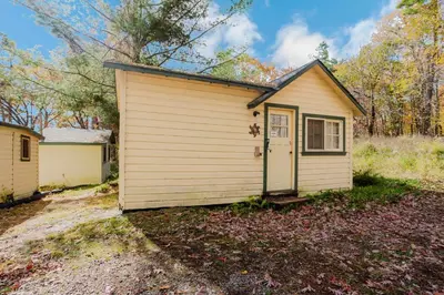 a tiny house in the middle of a yard at 1-Bedroom Cottage #1 - White Pine in Gravenhurst