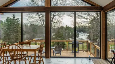 a screened in porch with a table and chairs at Lake Muskoka 2-bedroom Cottage - Pier 100 #50 in Port Carling