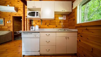a kitchen with white cabinets and a sink in a cabin at Lake Muskoka 3-bdrm Cottage - Pier 100 #70 in Port Carling