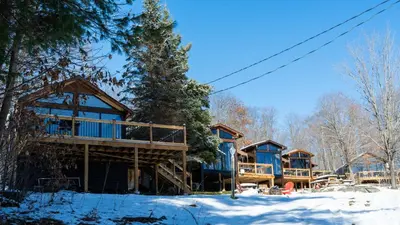 a log cabin in the winter with snow on the ground at Lake Muskoka Deluxe 2-bdrm Cottage - Pier 100 #60 in Port Carling