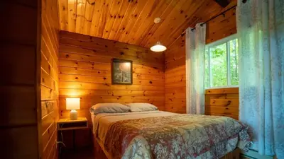a bedroom with a bed in a wooden cabin at Lake Muskoka 3-bedroom Cottage - Pier 100 #20 in Port Carling