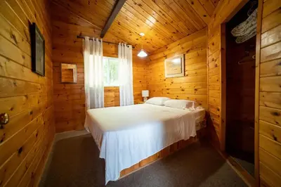a bedroom with a bed in a wooden cabin at Lake Muskoka 3-bedroom Cottage - Pier 100 #20 in Port Carling