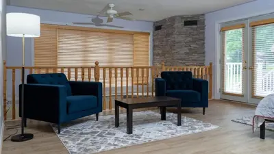 a living room with two blue chairs and a table at Muskoka Lakefront 4-bdrm Guest House in Port Carling