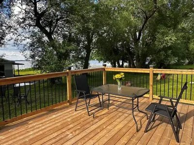 a patio with a table and chairs on a deck at 2-bedroom Lake Front Cottage in Harwood ON #6 in Harwood