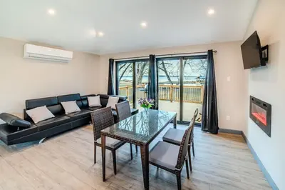 a living room with a table and a couch at 2-bedroom Lake Front Cottage in Harwood ON #6 in Harwood