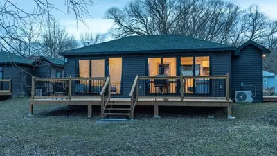 a small house with a large porch and a deck at 2-bedroom Lake Front Cottage in Harwood ON #4 in Harwood