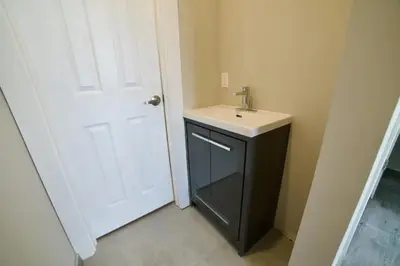 a bathroom with a sink and a white door at 1-bedroom Townhouse in Harwood #2 in Harwood
