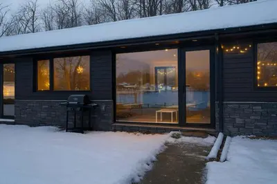 a house with glass windows in the snow at 1-bedroom Townhouse in Harwood #3 in Harwood