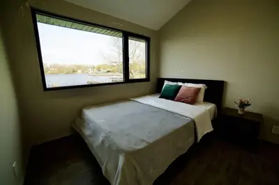 a bedroom with a bed with a large window at 1-bedroom Townhouse in Harwood #5 in Harwood